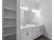 Bright bathroom with a double sink vanity, modern lighting and open shelving at 17339 Elmwood Ave, Port Charlotte, FL 33948