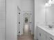 View of an interior hall from the bathroom with modern fixtures and wood-look tile flooring at 17339 Elmwood Ave, Port Charlotte, FL 33948