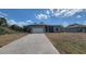 Single story home with neutral siding, a paved driveway, and a two car garage at 17339 Elmwood Ave, Port Charlotte, FL 33948