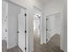 Hallway featuring white doors with matte black hardware and neutral-toned flooring at 17339 Elmwood Ave, Port Charlotte, FL 33948