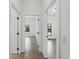 Bright hallway with tile flooring and white walls, showcasing access to various rooms within the home at 17339 Elmwood Ave, Port Charlotte, FL 33948