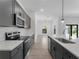 Modern kitchen with sleek gray cabinetry, stainless steel appliances, quartz countertops, and contemporary finishes at 17339 Elmwood Ave, Port Charlotte, FL 33948