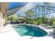 Sparkling screened-in pool with sun umbrella and outdoor seating at 2084 Zuyder Ter, North Port, FL 34286