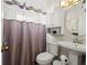 Cozy bathroom featuring a toilet, sink, decorative mirror, and shower at 209 Seminole Nw Blvd, Port Charlotte, FL 33952