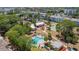 Aerial view showcases a blue pool and nearby tennis courts, surrounded by mature trees and landscaping at 21287 Gertrude Ave # 211, Port Charlotte, FL 33952