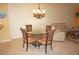 Well-lit dining area with tile floors, glass table, wicker chairs, and a view of the adjacent living room at 220 Coldeway Dr # 123, Punta Gorda, FL 33950