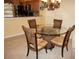 Dining area featuring tile flooring, a glass table with wicker chairs, and an open connection to the kitchen at 220 Coldeway Dr # 123, Punta Gorda, FL 33950