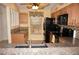 Charming kitchen with tan wooden cabinets, mosaic backsplash, and black appliances at 220 Coldeway Dr # 123, Punta Gorda, FL 33950