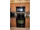 Kitchen featuring black microwave and oven range, tan cabinets, and mosaic backsplash at 220 Coldeway Dr # 123, Punta Gorda, FL 33950