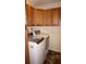 Modern laundry room with tan cabinets, laundry machines, and floral rug at 220 Coldeway Dr # 123, Punta Gorda, FL 33950