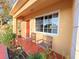 Inviting front porch with two wooden chairs, colorful plants, and a glimpse of the cozy interior at 22299 Catherine Ave, Port Charlotte, FL 33952