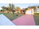Beautiful single-story home with a well-maintained lawn and a red colored driveway and inviting front entrance at 22299 Catherine Ave, Port Charlotte, FL 33952