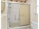 Bathroom featuring white-tiled shower, toilet, and window at 22385 Olean Blvd, Port Charlotte, FL 33952