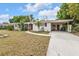 Charming one-story home with a well-manicured lawn, covered porch, and attached carport at 22385 Olean Blvd, Port Charlotte, FL 33952