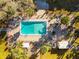 An aerial view shows the community pool, seating, grilling area, landscaping and surrounding buildings at 2290 Aaron St # 312, Port Charlotte, FL 33952