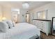 Bright bedroom with a white bed and dresser, offering a view of the ensuite bathroom at 2290 Aaron St # 312, Port Charlotte, FL 33952