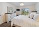 Cozy bedroom featuring a white bed, a dark wood dresser, and a window offering natural light at 2290 Aaron St # 312, Port Charlotte, FL 33952