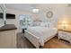 Bright bedroom featuring a large window and white furniture, including a bed, dresser, and nightstand at 2290 Aaron St # 312, Port Charlotte, FL 33952