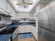 Bright kitchen featuring white cabinets, stainless steel refrigerator, blue counters, and an overhead fan at 2290 Aaron St # 312, Port Charlotte, FL 33952
