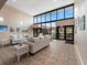 Spacious community room with sofas, art, soaring ceilings, and large windows overlooking outside area at 2290 Aaron St # 312, Port Charlotte, FL 33952
