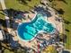 Aerial view of a kidney-shaped pool surrounded by lounge chairs and lush landscaping at 2290 Aaron St # 312, Port Charlotte, FL 33952