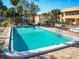 Community pool with crystal clear water, surrounded by a paved deck and green landscaping at 2290 Aaron St # 312, Port Charlotte, FL 33952