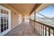 Long, tiled balcony featuring a wood railing and screened enclosure at 23240 Fullerton Ave, Punta Gorda, FL 33980