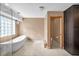 Bathroom featuring soaking tub, pendant lighting, walk-in closet and toilet at 23240 Fullerton Ave, Punta Gorda, FL 33980