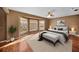 Sunlit main bedroom featuring bay windows, ceiling fan and sleek hardwood floors, with view at 23240 Fullerton Ave, Punta Gorda, FL 33980