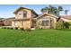 Charming two-story home boasts a lush green lawn and meticulously manicured landscaping at 23240 Fullerton Ave, Punta Gorda, FL 33980