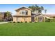 Inviting two-story home with a well-maintained lawn and neatly trimmed hedges, showcasing curb appeal at 23240 Fullerton Ave, Punta Gorda, FL 33980