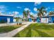 Serene backyard with a pool, a pathway, and a blue house, creating a relaxing and inviting outdoor living space at 23451 Harper Ave, Port Charlotte, FL 33980