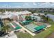 Aerial view of community amenities: pool, shuffleboard, bocce ball, and clubhouse, surrounded by lush landscaping at 24321 Kintail Ct, Punta Gorda, FL 33980