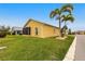 Rear view of home showing a spacious yard, two palm trees and a large screened in lanai at 24321 Kintail Ct, Punta Gorda, FL 33980