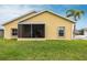 Backyard view with a screened-in patio and green grass at 24321 Kintail Ct, Punta Gorda, FL 33980