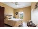 Comfortable bedroom with a floral comforter, ceiling fan, and a window with blinds at 24321 Kintail Ct, Punta Gorda, FL 33980