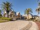 Inviting clubhouse entrance with lush landscaping and a beautifully paved drive under a bright blue sky at 24321 Kintail Ct, Punta Gorda, FL 33980