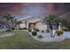 Beautiful exterior elevation showcasing the manicured lawn, lush landscaping, charming curb appeal and mature palms at 24321 Kintail Ct, Punta Gorda, FL 33980