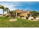 Beautiful home with a lush front yard, mature palm trees, and a well-maintained lawn at 24321 Kintail Ct, Punta Gorda, FL 33980