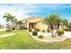 Charming single-story home featuring a well-manicured lawn, lush landscaping, and mature palm trees creating great curb appeal at 24321 Kintail Ct, Punta Gorda, FL 33980