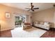 Cozy living room with a ceiling fan, comfortable sofas, and a sliding glass door that leads to the patio at 24321 Kintail Ct, Punta Gorda, FL 33980