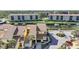 Aerial view of yellow townhouses with boat dock access and lush landscaping in a waterfront community at 25188 Marion Ave # 1015, Punta Gorda, FL 33950