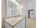 Bathroom with granite countertop, white cabinets, and doorway to the laundry room at 25188 Marion Ave # 1015, Punta Gorda, FL 33950
