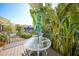 A cozy patio with a table and umbrella overlooks a tranquil canal and is surrounded by beautiful tropical plants at 25188 Marion Ave # 1015, Punta Gorda, FL 33950