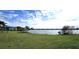 Expansive view of the lake and lush green lawn, a beautiful scene from the property at 25225 Rampart Blvd # 604, Punta Gorda, FL 33983