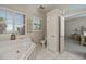 Bathroom with jetted tub, three-pane window, blinds, white walls, and vanity on the left at 26089 Templar Ln, Punta Gorda, FL 33983