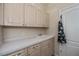 Bright laundry room features upper and lower cabinets and a utility sink at 26089 Templar Ln, Punta Gorda, FL 33983