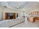 Spacious living area featuring an open floor plan, a dining area, a large sectional couch, and a tray ceiling at 26089 Templar Ln, Punta Gorda, FL 33983