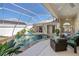 The screened-in pool and spa area offer an outdoor lifestyle with lush plants and comfortable seating options at 26089 Templar Ln, Punta Gorda, FL 33983