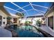 The backyard features a screened-in pool and spa, surrounded by tropical plants and an expansive patio area at 26089 Templar Ln, Punta Gorda, FL 33983